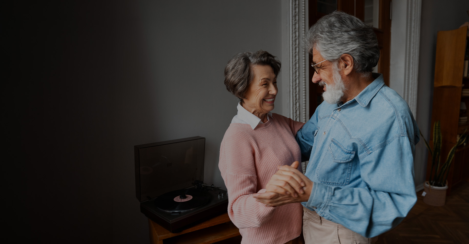 Casal de idosos dançando e sorrindo em casa