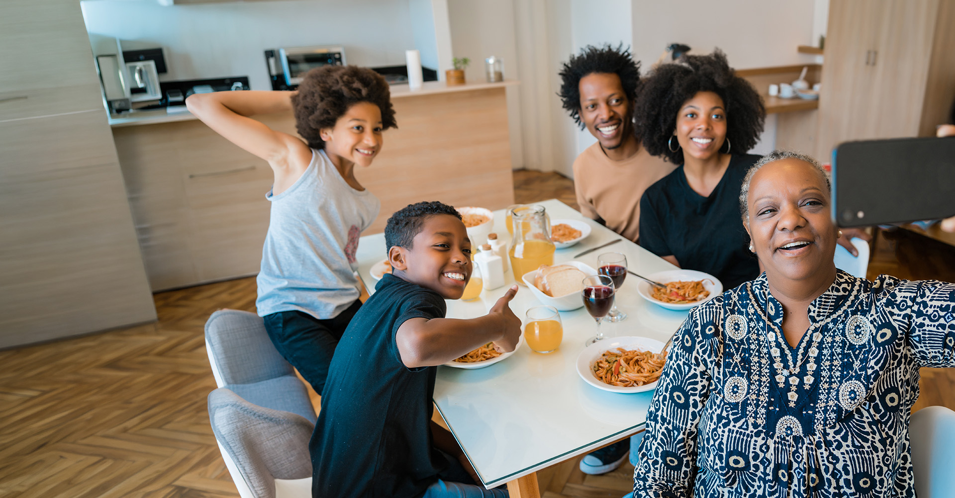 Família reunida à mesa fazendo uma selfie